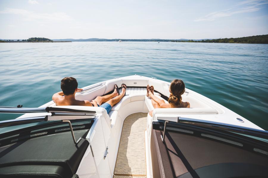 A man and a woman sit in the bow of a boat looking across the water on Table Rock Lake