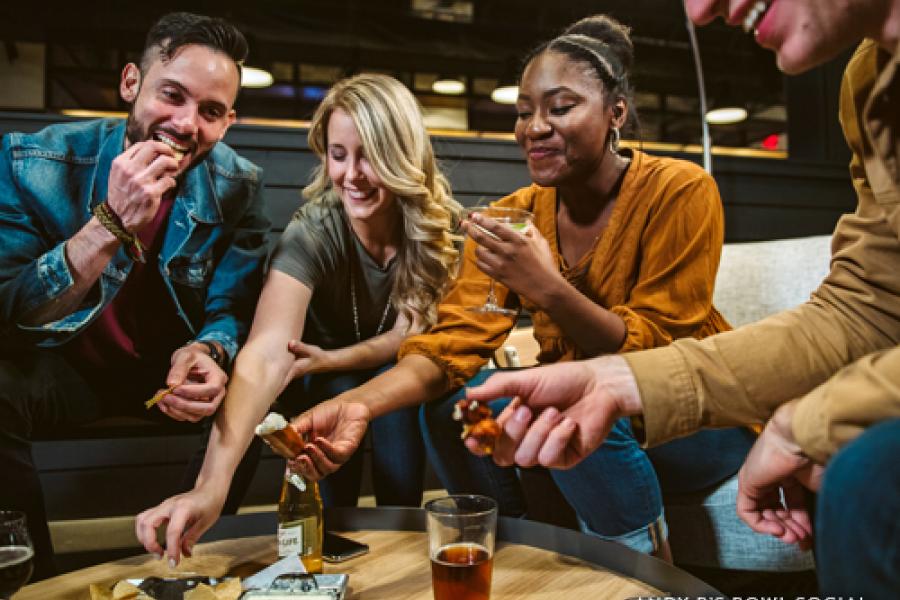Group of friends eating and drinking at a bowling alley night club in Branson.