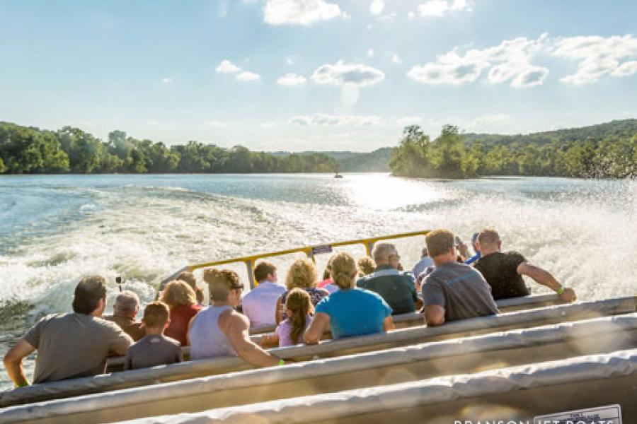 People being splashed and enjoying thrilling boat attraction.