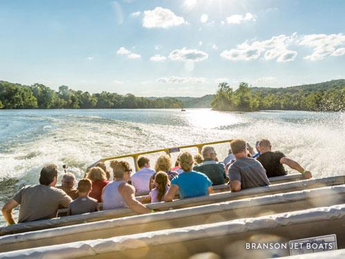 People being splashed and enjoying thrilling boat attraction.