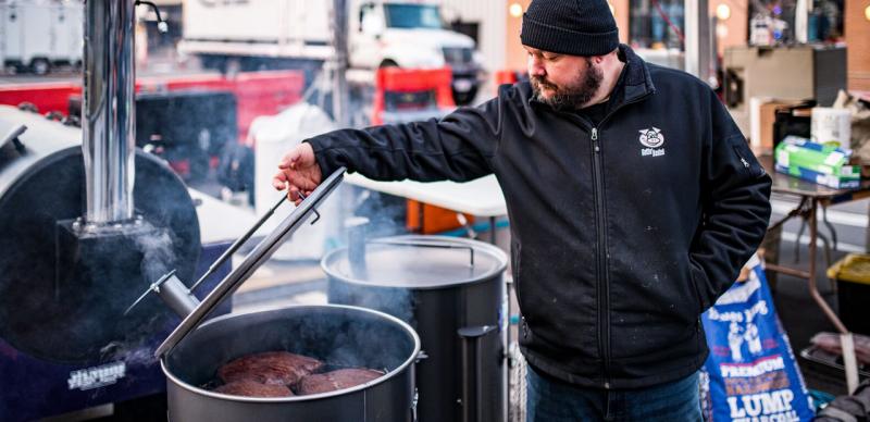 Man cooking barbecue in 55-gallon barrel in Branson.