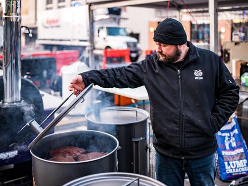 Man cooking barbecue in 55-gallon barrel in Branson. 