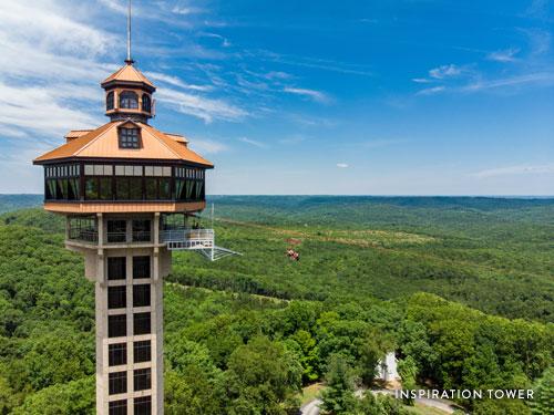 A group of friends riding ziplines off a tall tower in Branson.