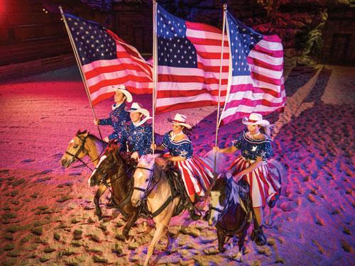 Four performers riding horses and singing in Branson show. 