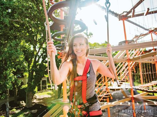 Woman climbing through outdoor ropes course in Branson.