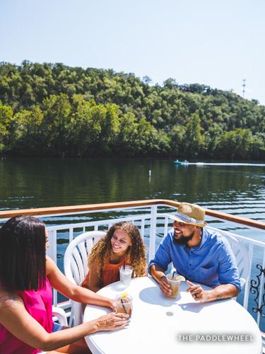 Family of three enjoying an outdoor patio meal on the bank of Lake Taneycomo.